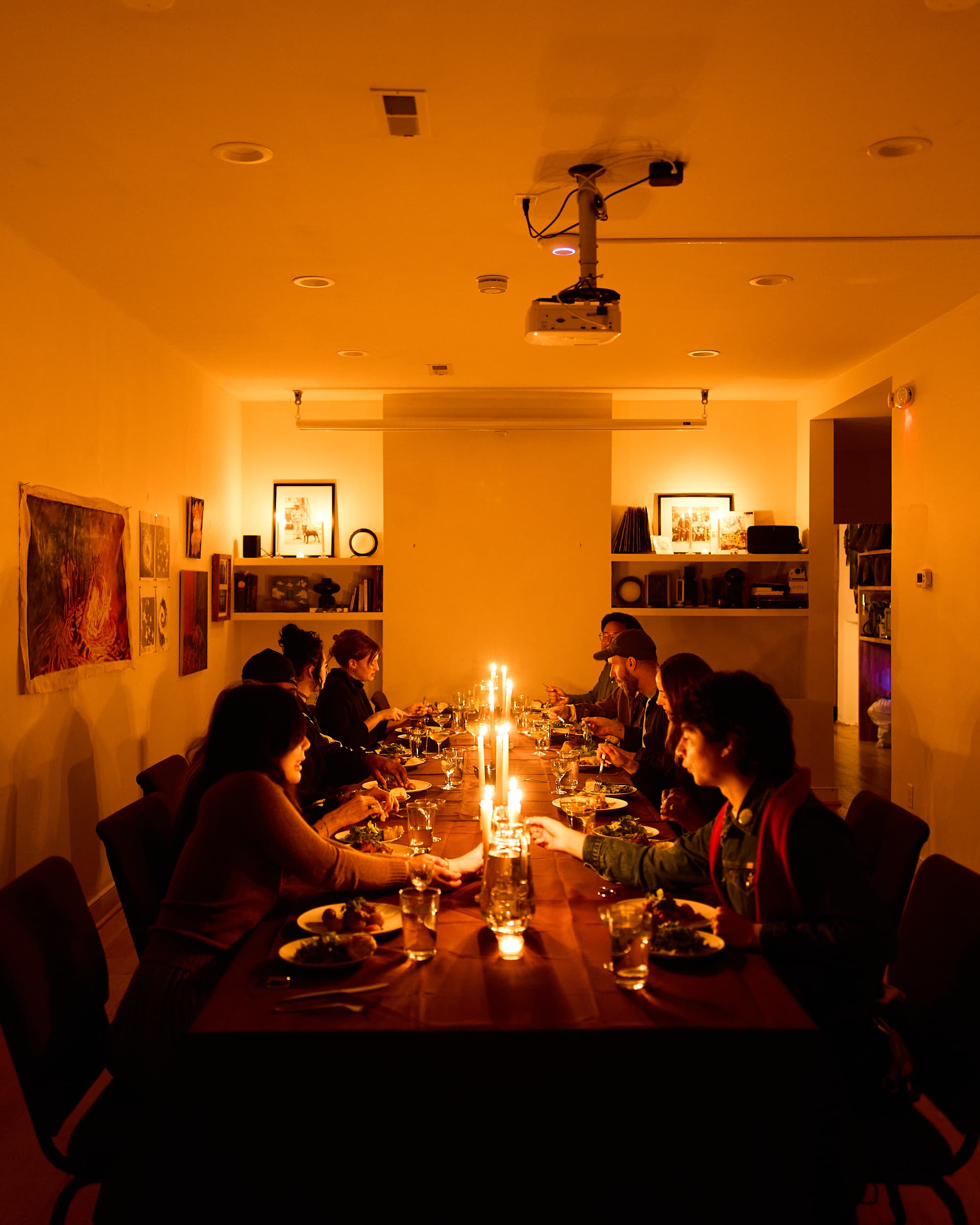 A candlelit dinner at a long table at Ours
