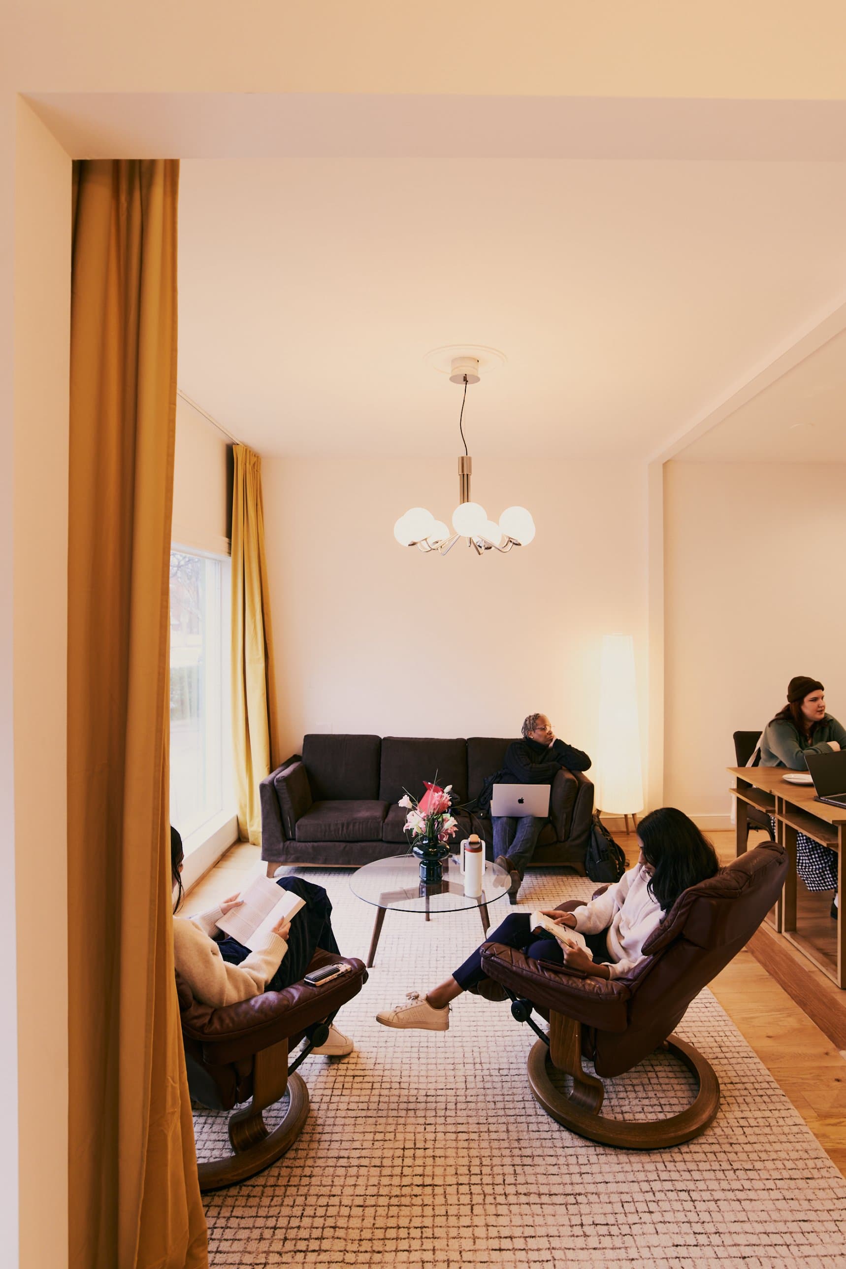 The lounge, with a couch and two leather armchairs by the front window